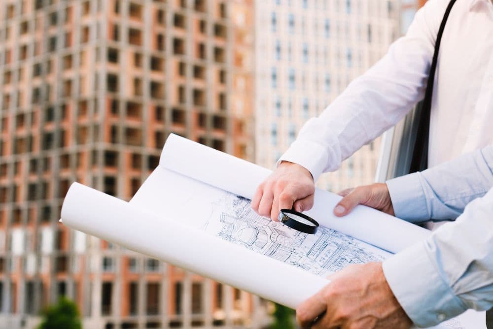 Engineers reviewing building plans at a construction site.